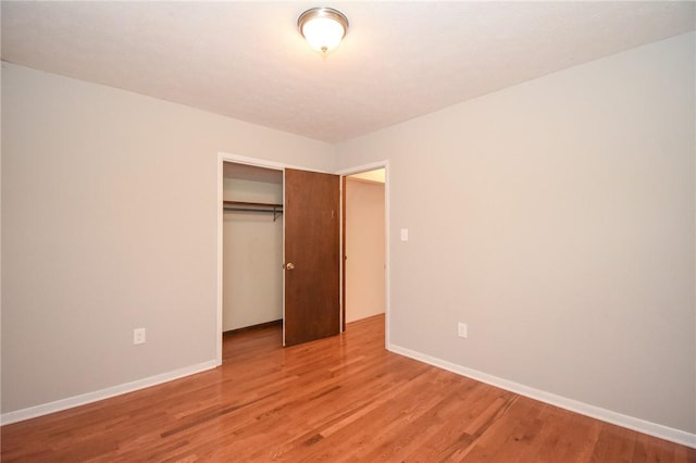 unfurnished bedroom with hardwood / wood-style flooring and a closet