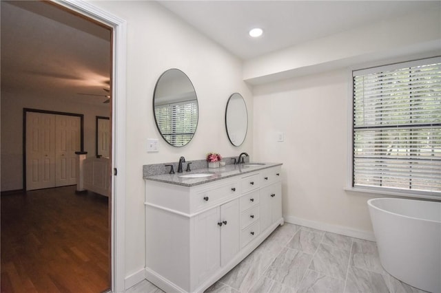 bathroom with vanity, plenty of natural light, a tub, and ceiling fan