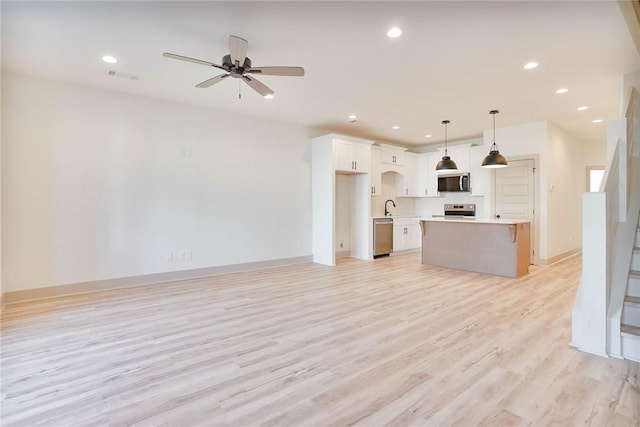 305 Northgate Blvd, Auburn, AL 36830 - unfurnished living room with light wood-type flooring, recessed lighting, a ceiling fan, a sink, and baseboards