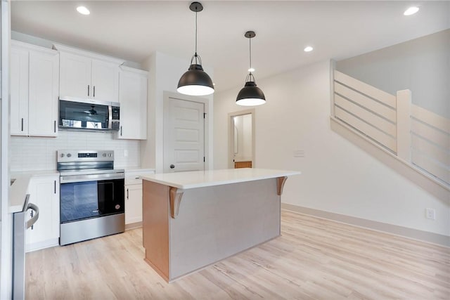305 Northgate Blvd, Auburn, AL 36830 - kitchen featuring stainless steel appliances, white cabinets, light wood-type flooring, a kitchen island, and backsplash