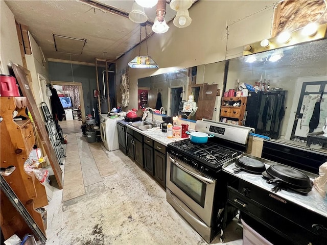 kitchen with a sink, dark cabinets, light countertops, washer / dryer, and stainless steel range with gas stovetop