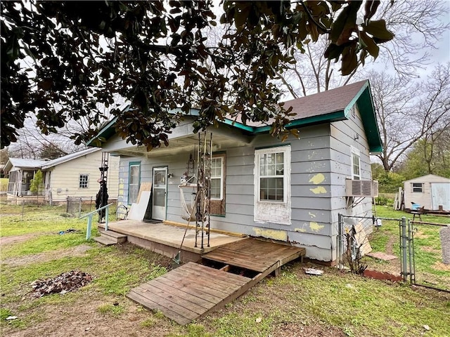 back of property featuring a gate, a yard, a wooden deck, and fence