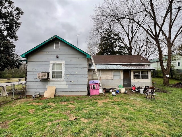 rear view of house with a lawn and fence