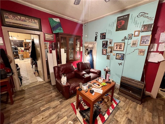 living room featuring ornamental molding, a textured ceiling, ceiling fan, and wood finished floors