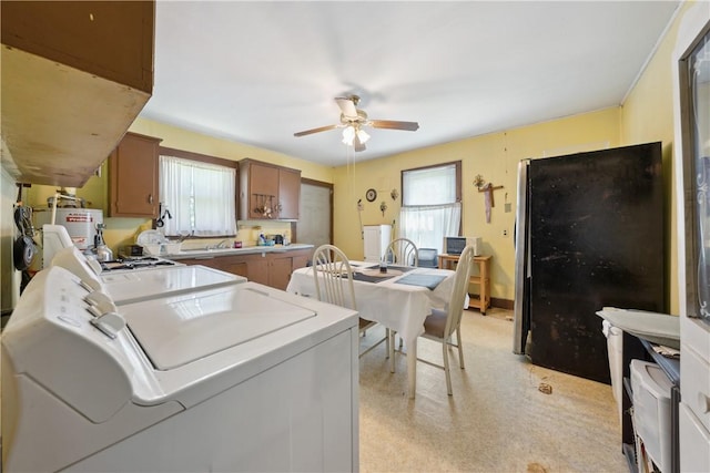 laundry area with separate washer and dryer, plenty of natural light, and ceiling fan
