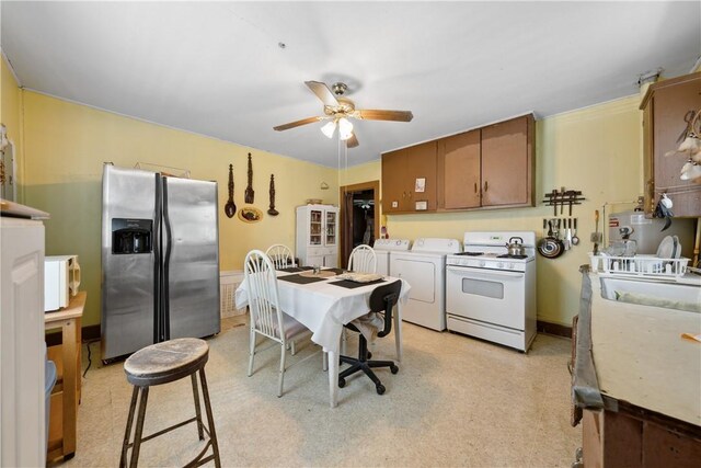 kitchen featuring light countertops, a ceiling fan, white appliances, washing machine and clothes dryer, and brown cabinetry