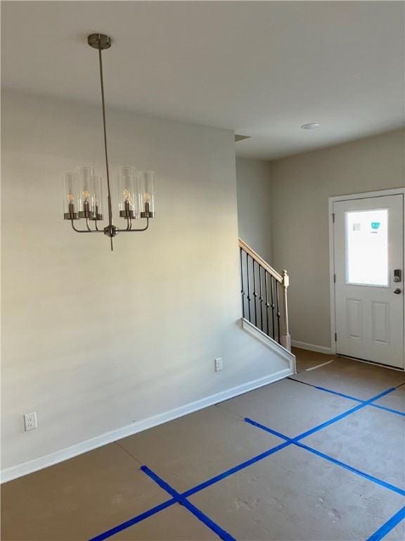 entrance foyer with a chandelier, baseboards, and stairs