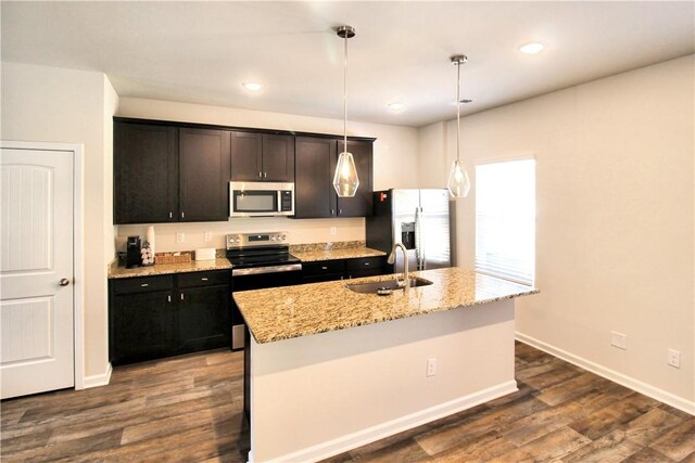 kitchen featuring dark wood finished floors, stainless steel appliances, baseboards, and a sink