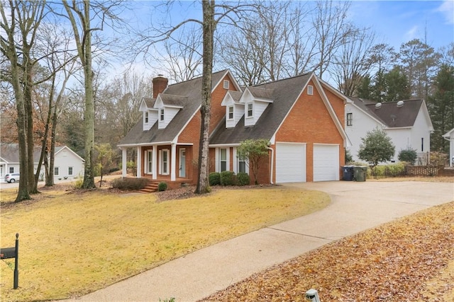 view of front of property with a chimney, driveway, covered porch, brick siding, and a garage