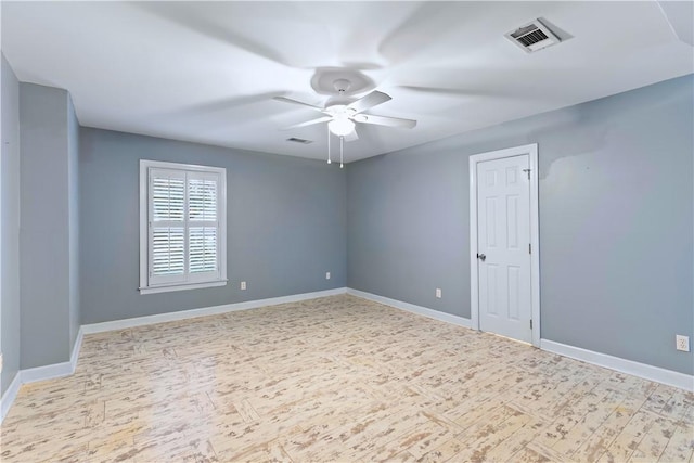 empty room with ceiling fan, baseboards, wood finished floors, and visible vents