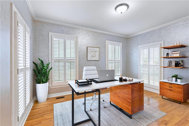 office space featuring ornamental molding, a healthy amount of sunlight, light wood-style floors, and visible vents