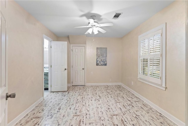 unfurnished room featuring a ceiling fan, wood finished floors, visible vents, and plenty of natural light