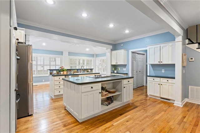 kitchen featuring dark countertops, light wood-style flooring, freestanding refrigerator, and visible vents