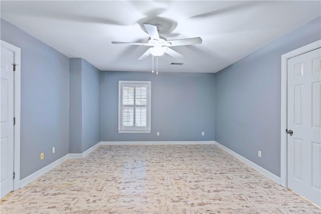 empty room featuring ceiling fan, baseboards, and visible vents