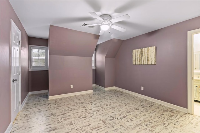 additional living space featuring ceiling fan, baseboards, lofted ceiling, and visible vents