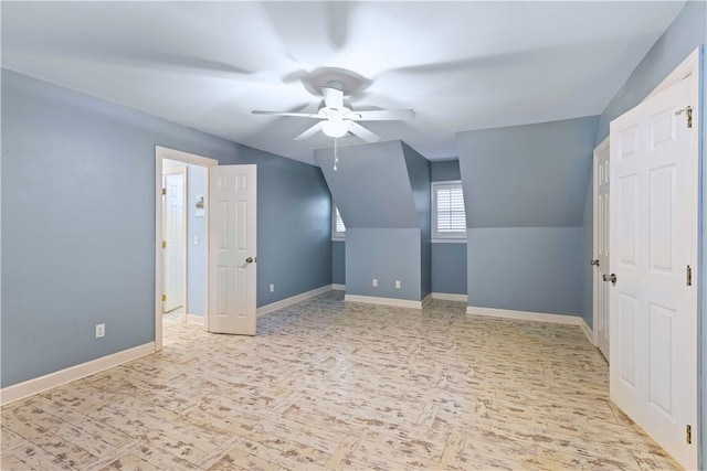 additional living space featuring a ceiling fan, baseboards, and vaulted ceiling