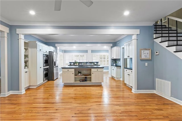kitchen featuring dark countertops, open shelves, light wood-type flooring, stainless steel refrigerator with ice dispenser, and visible vents
