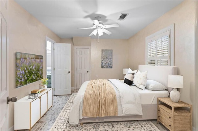 bedroom with ceiling fan, visible vents, and light wood-type flooring