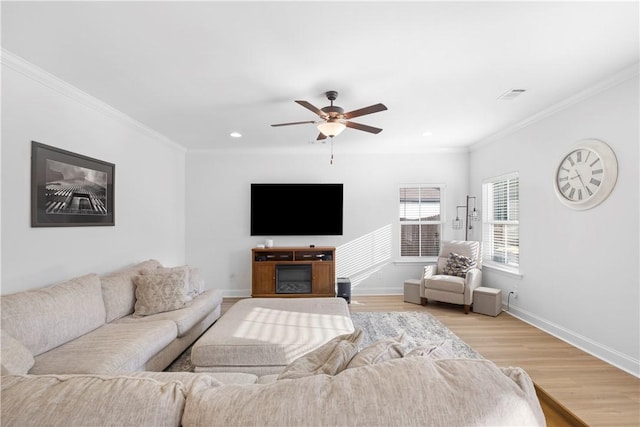 living area with crown molding, ceiling fan, light wood finished floors, and visible vents