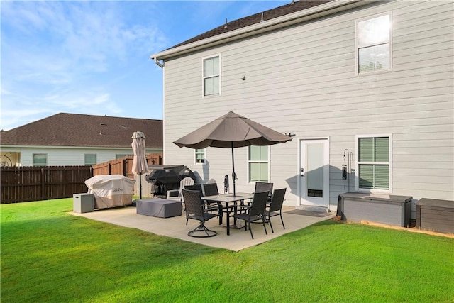 rear view of property featuring a lawn, fence, and a patio area