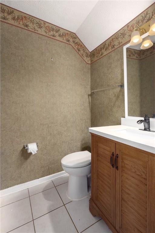 2428 E University Dr Unit 904, Auburn, AL 36830 - bathroom with toilet, vanity, lofted ceiling, tile patterned flooring, and wallpapered walls