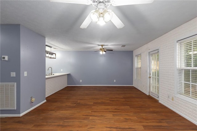 2428 E University Dr Unit 904, Auburn, AL 36830 - unfurnished living room featuring brick wall, a ceiling fan, wood finished floors, a sink, and baseboards