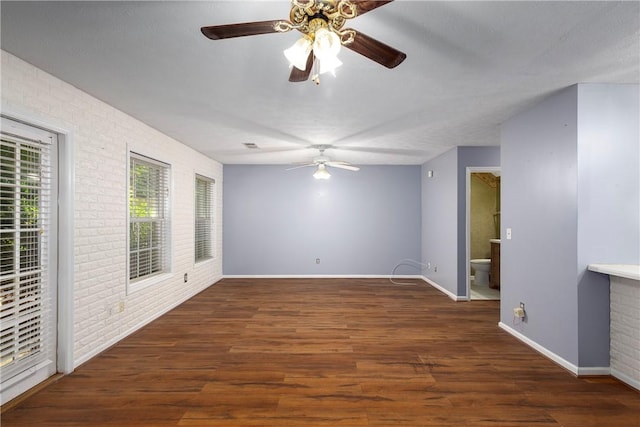 2428 E University Dr Unit 904, Auburn, AL 36830 - empty room featuring a ceiling fan, baseboards, brick wall, and wood finished floors