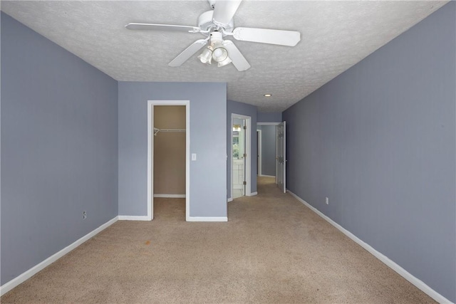 2428 E University Dr Unit 904, Auburn, AL 36830 - unfurnished bedroom featuring a textured ceiling, carpet floors, a walk in closet, baseboards, and a closet
