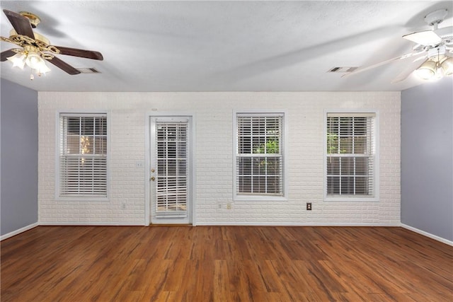 2428 E University Dr Unit 904, Auburn, AL 36830 - unfurnished room featuring brick wall, ceiling fan, baseboards, and wood finished floors