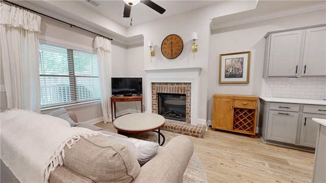 574 Grey Oak Cir, Auburn, AL 36830 - living room with ceiling fan, a fireplace, light wood-style flooring, and ornamental molding