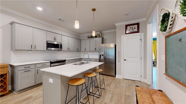 574 Grey Oak Cir, Auburn, AL 36830 - kitchen featuring stainless steel appliances, gray cabinets, a kitchen breakfast bar, backsplash, and light wood-style flooring