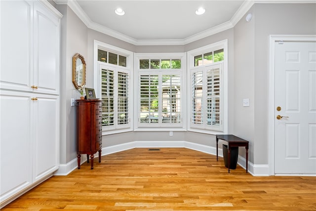 entryway featuring crown molding and light hardwood / wood-style flooring