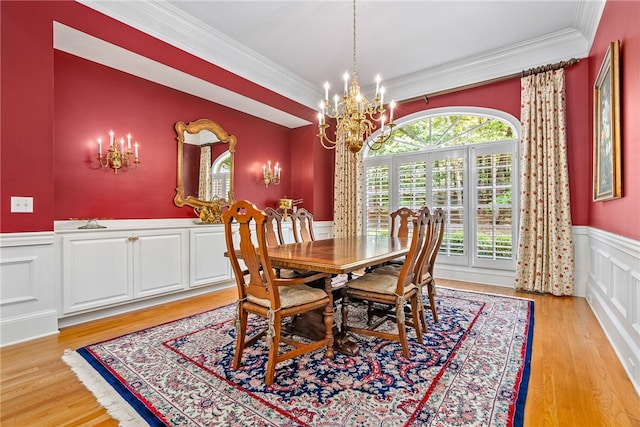 dining area with crown molding, light hardwood / wood-style flooring, and a chandelier