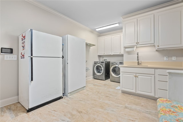 laundry area with separate washer and dryer, sink, cabinets, and ornamental molding