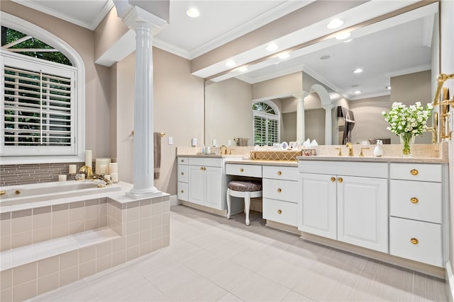 bathroom featuring vanity, a relaxing tiled tub, ornate columns, and crown molding