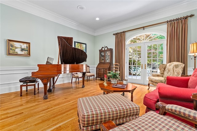 living area featuring light hardwood / wood-style floors, ornamental molding, and french doors