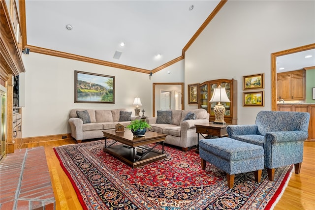 living room featuring light hardwood / wood-style floors, high vaulted ceiling, and ornamental molding