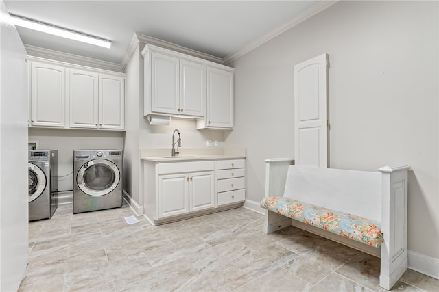 clothes washing area featuring cabinets, washing machine and clothes dryer, crown molding, and sink