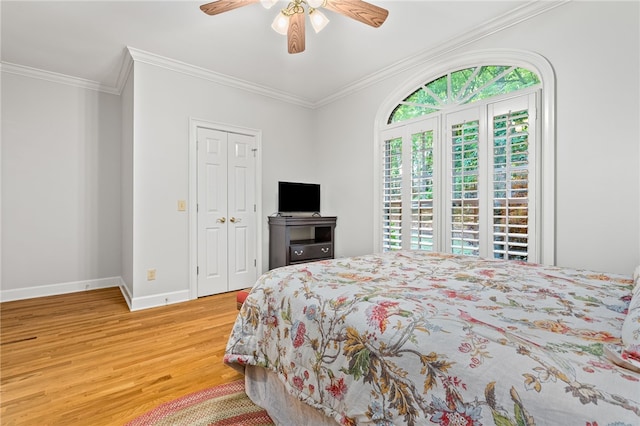 bedroom featuring hardwood / wood-style floors, a closet, ceiling fan, and crown molding