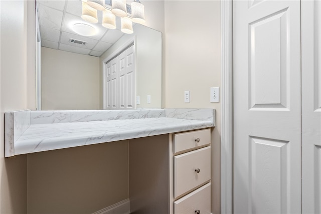 bathroom with a drop ceiling and vanity