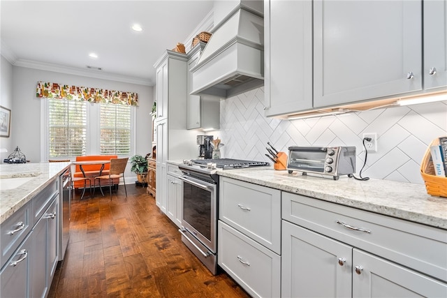 kitchen featuring premium range hood, appliances with stainless steel finishes, crown molding, and light stone counters