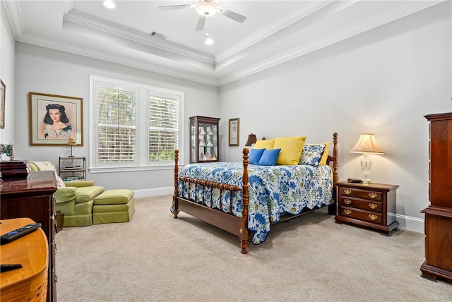 carpeted bedroom with a raised ceiling, ornamental molding, and ceiling fan