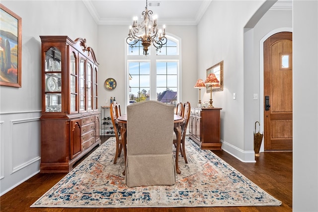 dining space with crown molding, dark hardwood / wood-style floors, and a chandelier