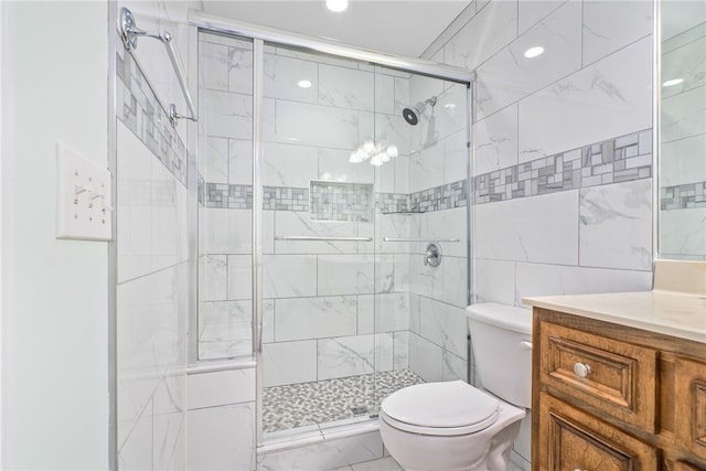 bathroom featuring vanity, toilet, walk in shower, and tile walls