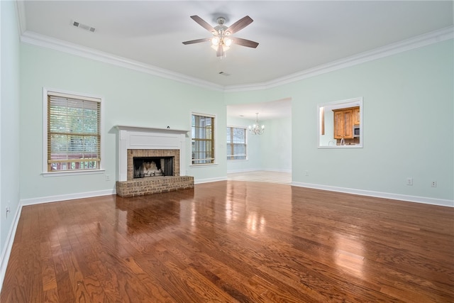 unfurnished living room featuring hardwood / wood-style flooring, a fireplace, crown molding, and ceiling fan with notable chandelier