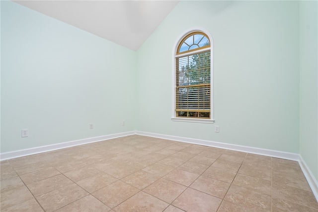 unfurnished room featuring light tile patterned flooring and lofted ceiling