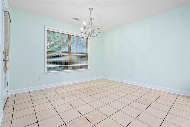 tiled empty room with a chandelier