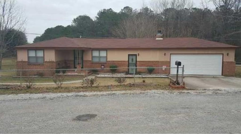 30 Bay St, Tuskegee, AL 36083 - ranch-style home featuring a fenced front yard, driveway, an attached garage, and a chimney