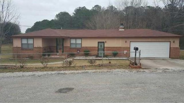 30 Bay St, Tuskegee, AL 36083 - ranch-style home featuring a fenced front yard, driveway, an attached garage, and a chimney