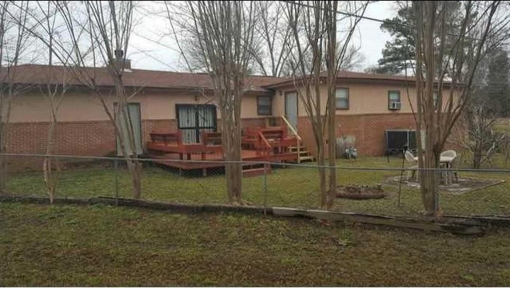 30 Bay St, Tuskegee, AL 36083 - rear view of property with a fenced backyard and stucco siding